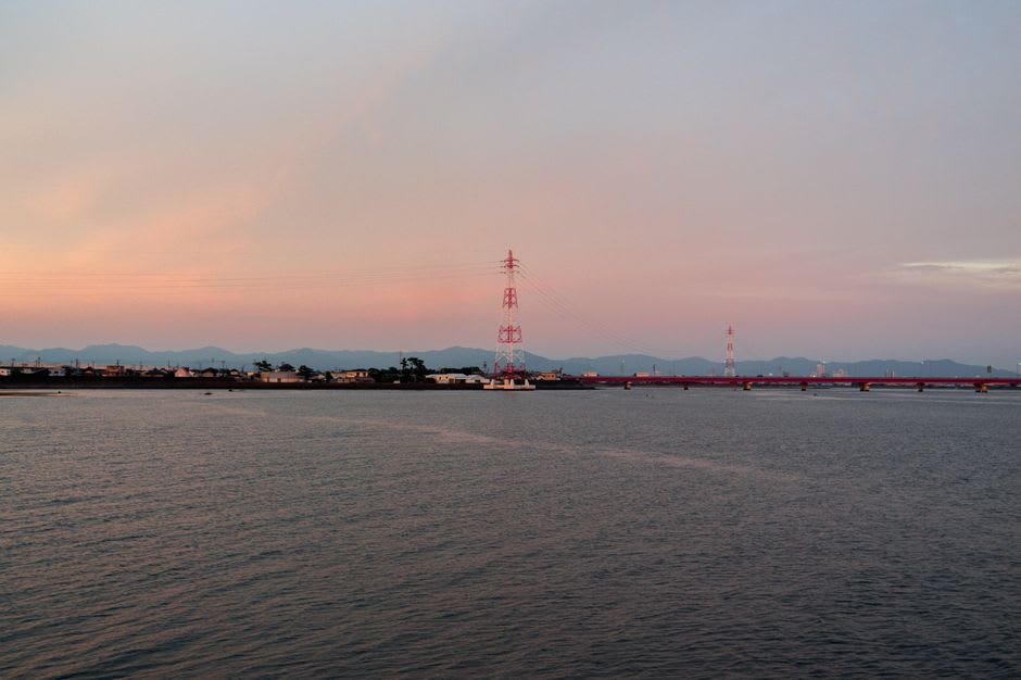 A walkway leading out over rocky tide pools to a round undersea observation tower at Katsuura Kaichu Park