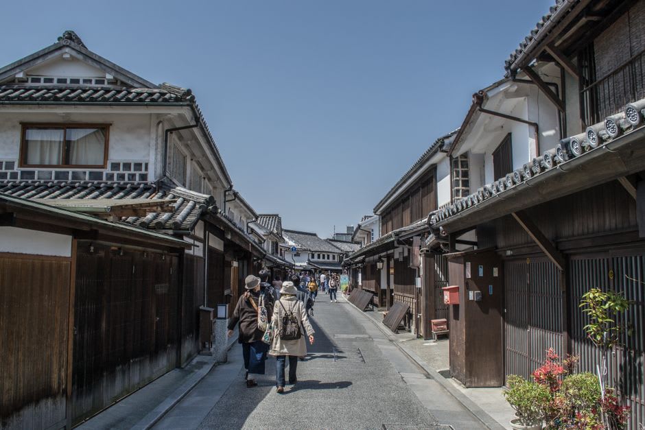 The neoclassical stone facade of the Ohara Museum of Art in Kurashiki, its columns contrasting with the traditional wooden buildings around it