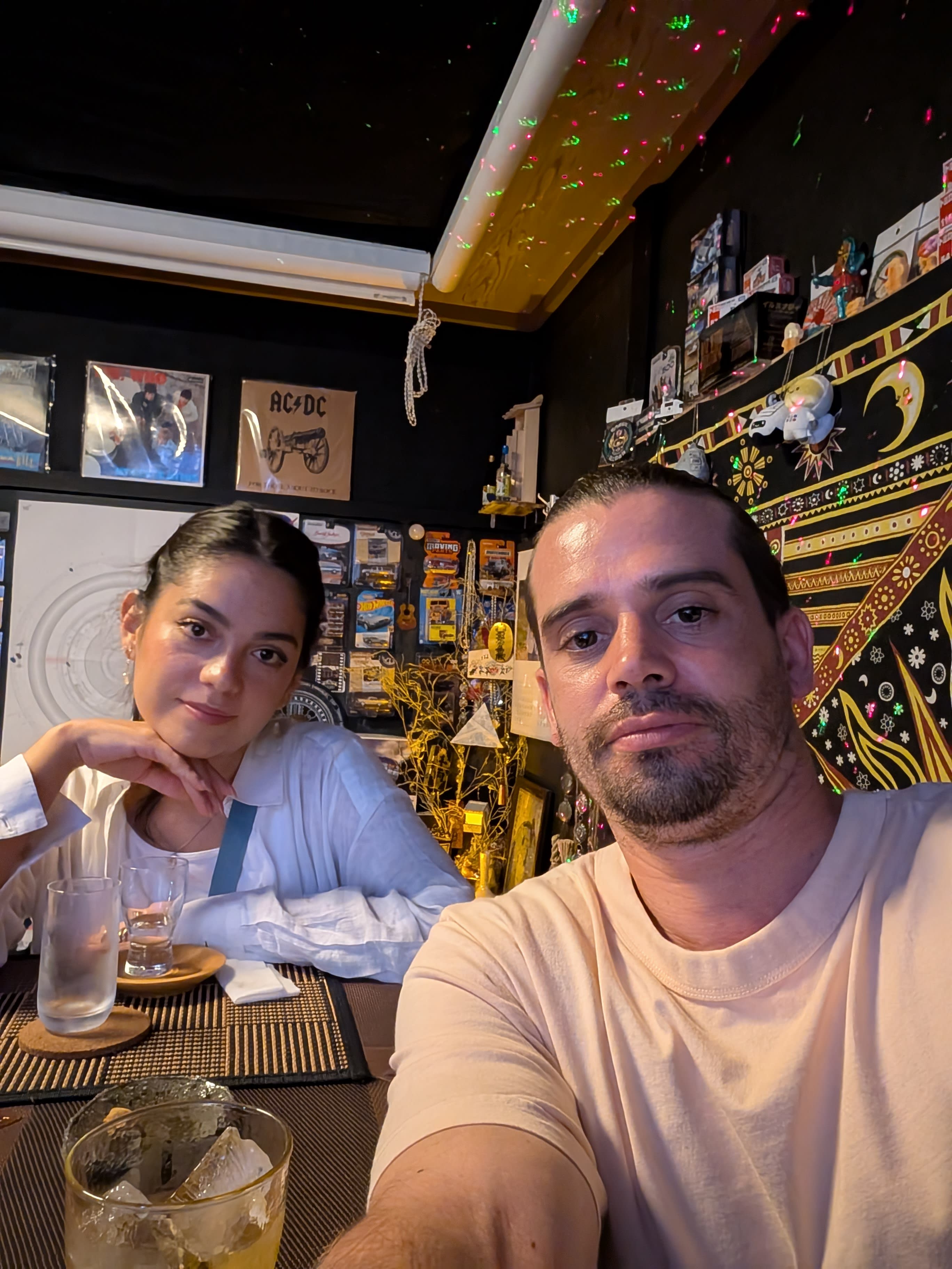 Pierre and Lia at a tiny bar in Kyoto — whisky on the table, posters on the walls, the kind of place you find by accident and remember forever