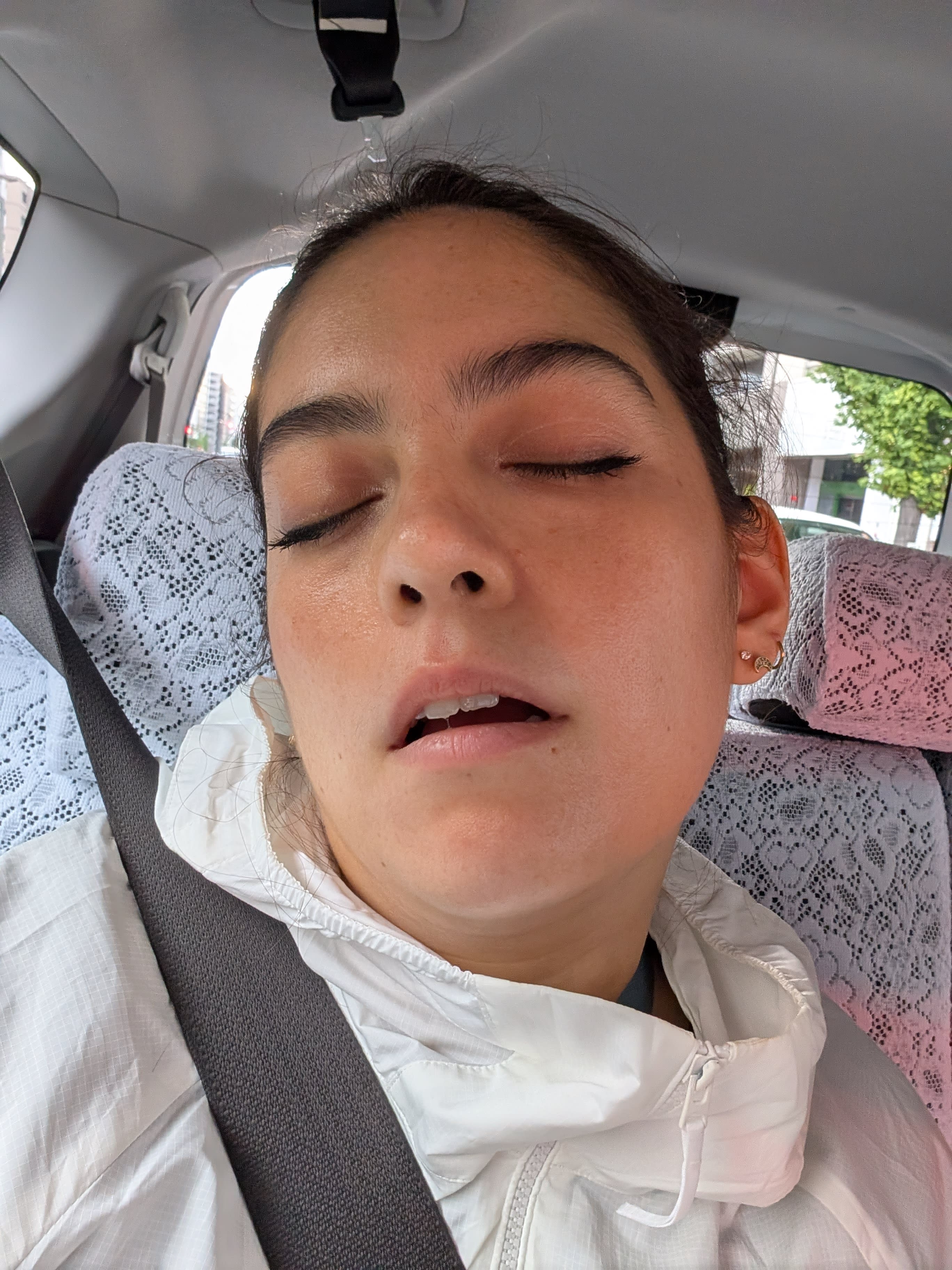 Lia asleep in the taxi on the way to Kyoto Station — five days of temples, mountains, and torii gates finally catching up with her