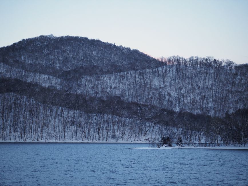 A steaming lakeside foot bath at dusk in Akankohan on the shore of Lake Akan