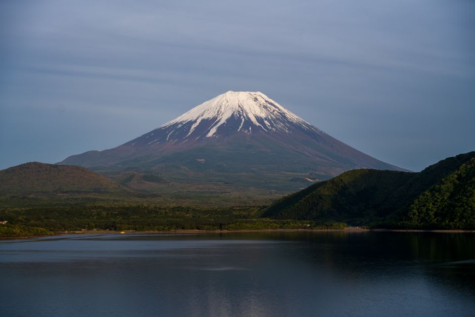 Mount Fuji doubled in the mirror-still water of Lake Motosu at first light