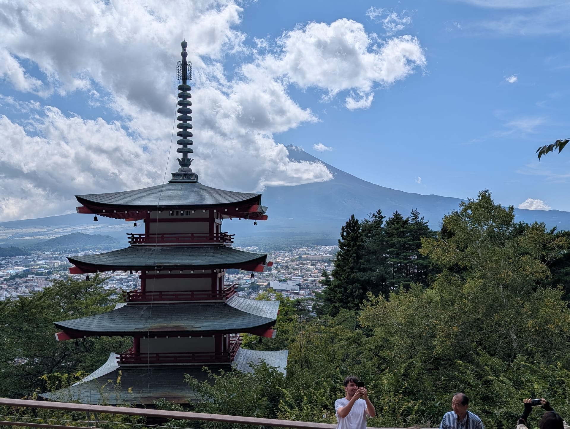 Chureito Pagoda with Mt. Fuji emerging from clouds behind it, the valley spread below — the photograph that sells Japan to the world, and it is real