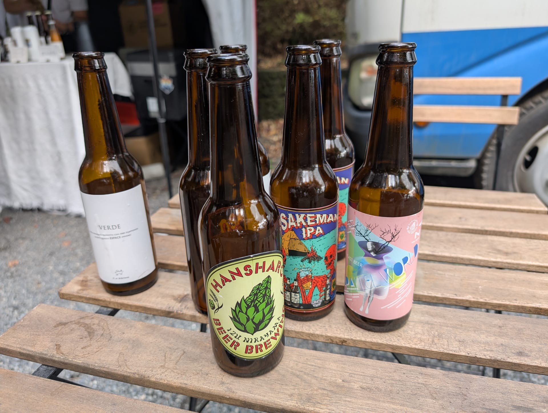 A selection of local Japanese craft beers on a wooden table — Sakeman IPA, Hansharo, and others with colourful labels
