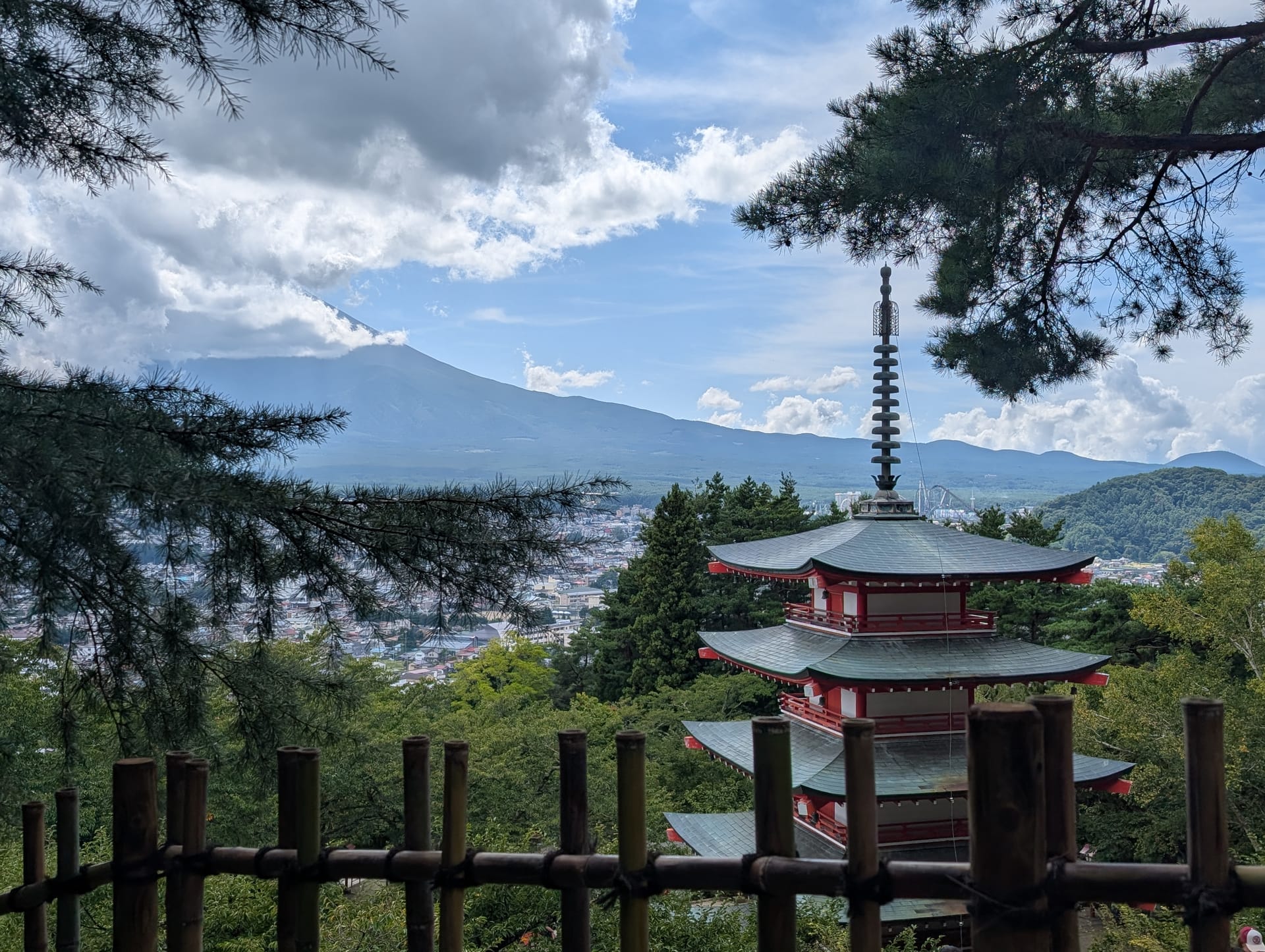 The pagoda framed by pine branches, with the valley and Fuji in the hazy distance