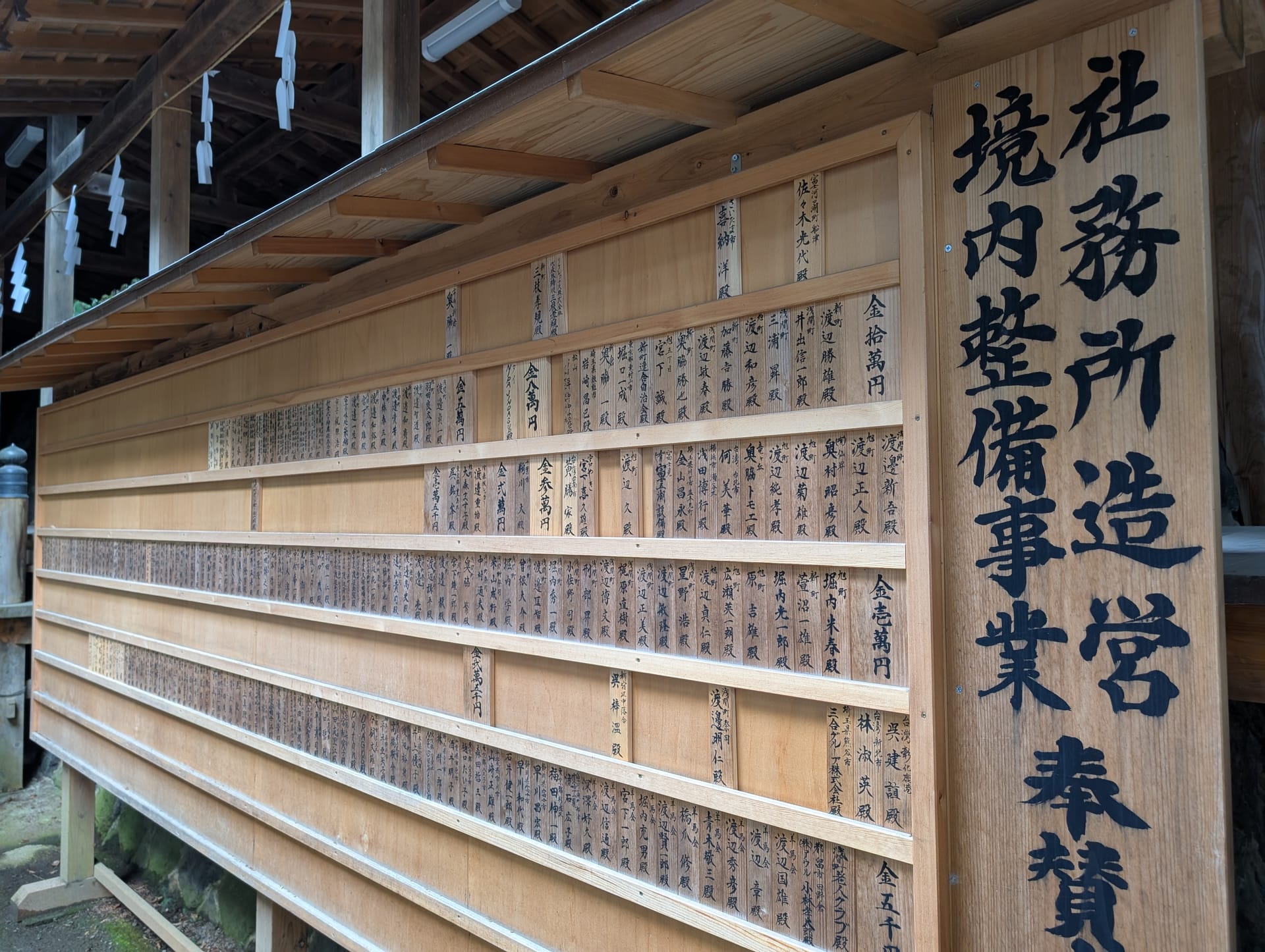 Wooden donor boards at the shrine, columns of kanji names written in ink
