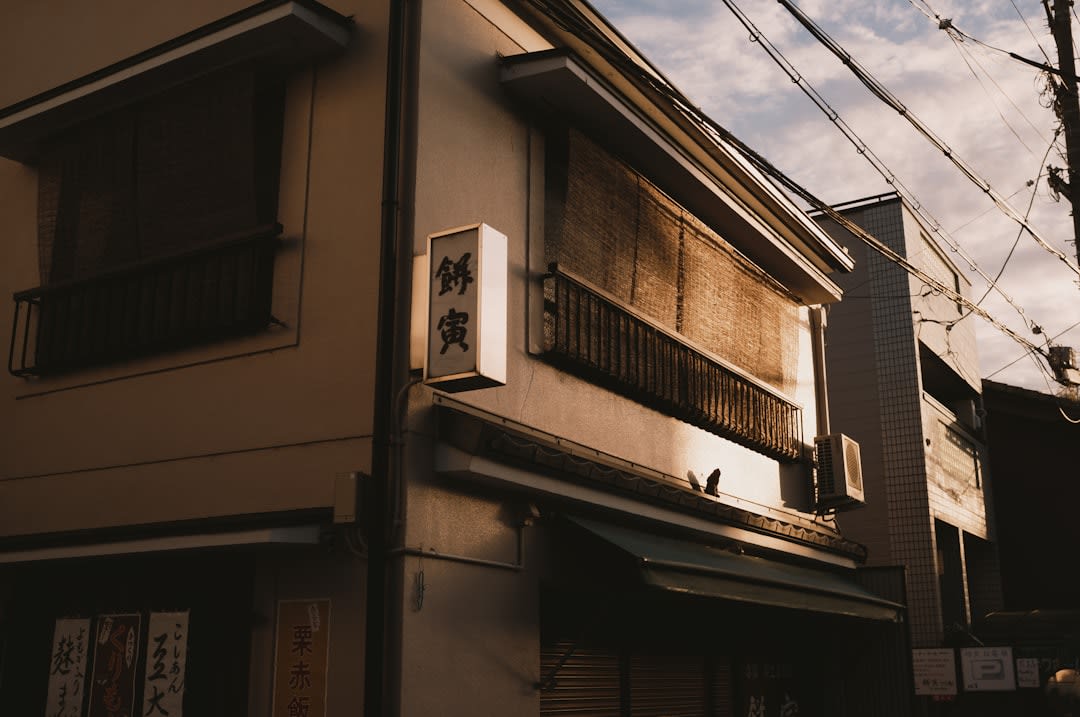A long stretch of Narai's main street, two-story wooden houses with dark lattice fronts and projecting upper floors receding into the distance