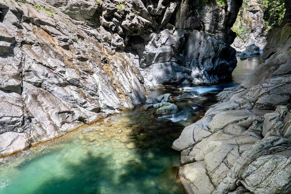 Clear turquoise pools of the Niyodo River between mossy boulders