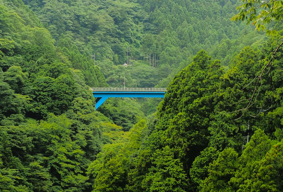 The long concrete crest of Ogouchi Dam above the green reservoir water