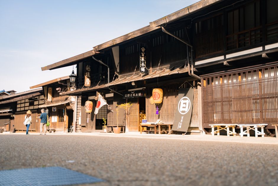 A towering wooden festival float in Sawara topped with a large carved historical figure, displayed inside the float exhibition hall