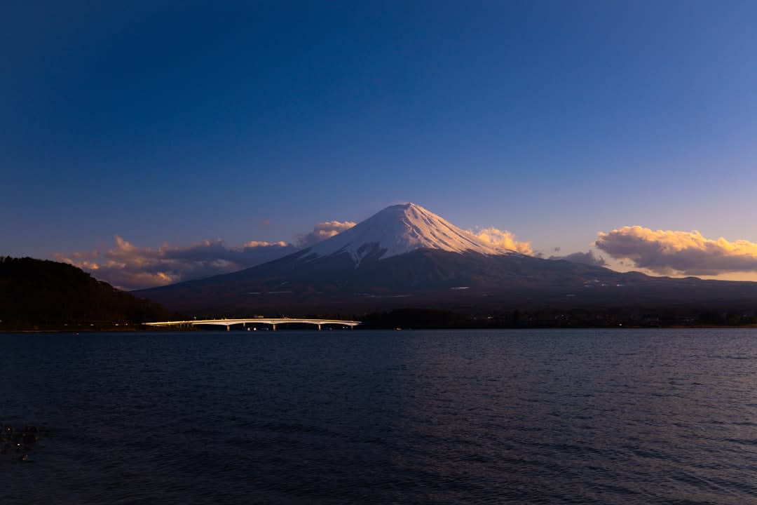 A lakeside foot bath steaming at the edge of frozen Lake Suwa with mountains beyond