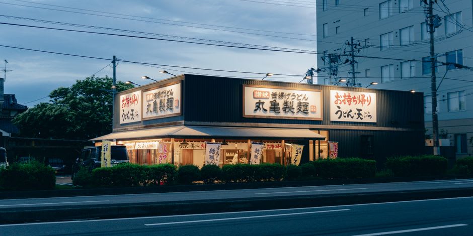 A bowl of thick sanuki udon with tempura at a Takamatsu counter shop