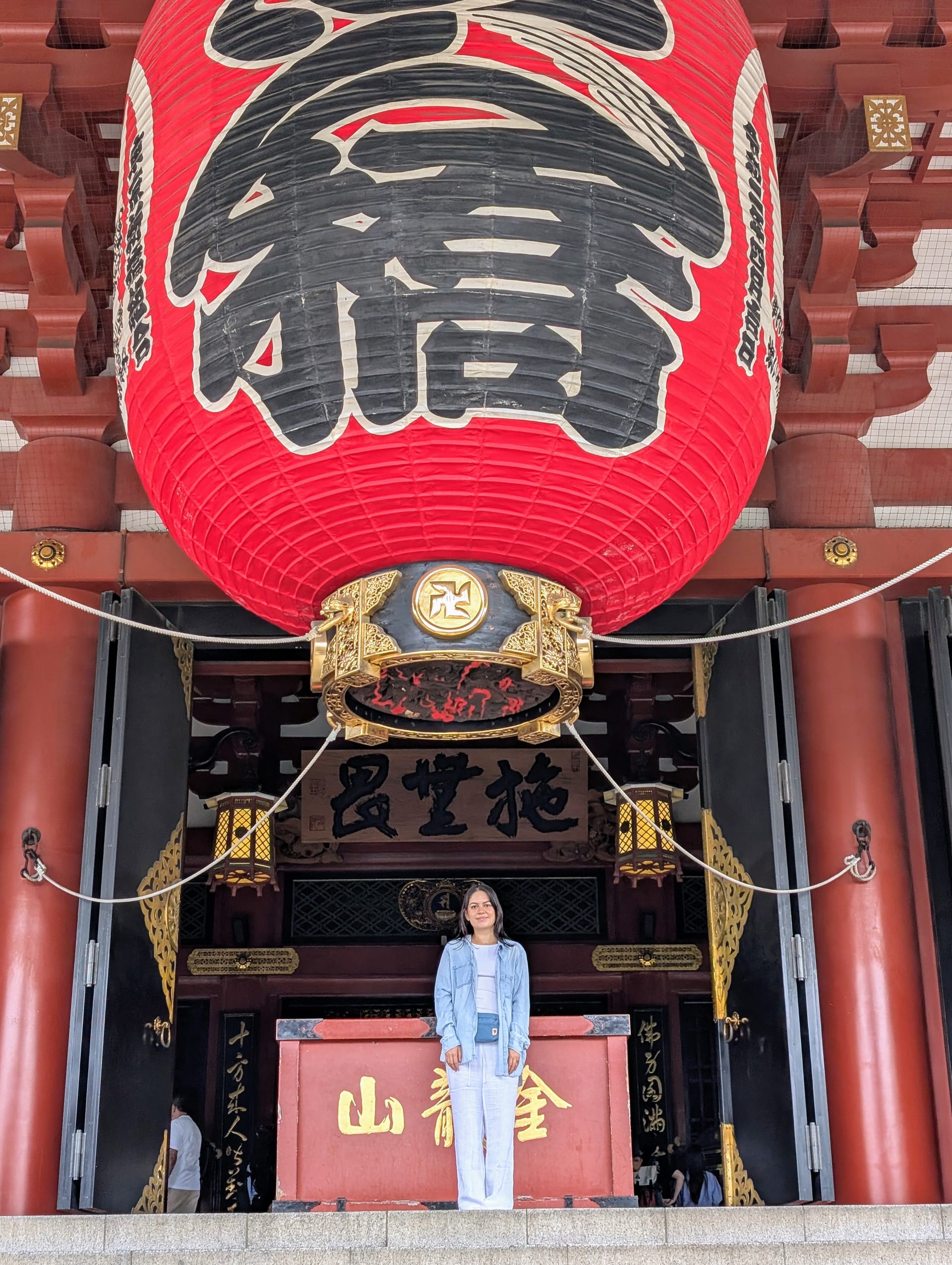 Lia standing beneath the massive red lantern at Senso-ji, dwarfed by the gate above her — this was the moment Japan became real