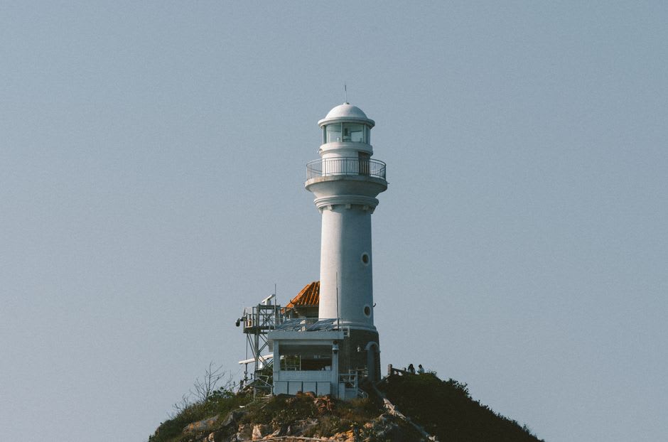 The white granite lighthouse at the western tip of Tsunoshima island under a blue sky