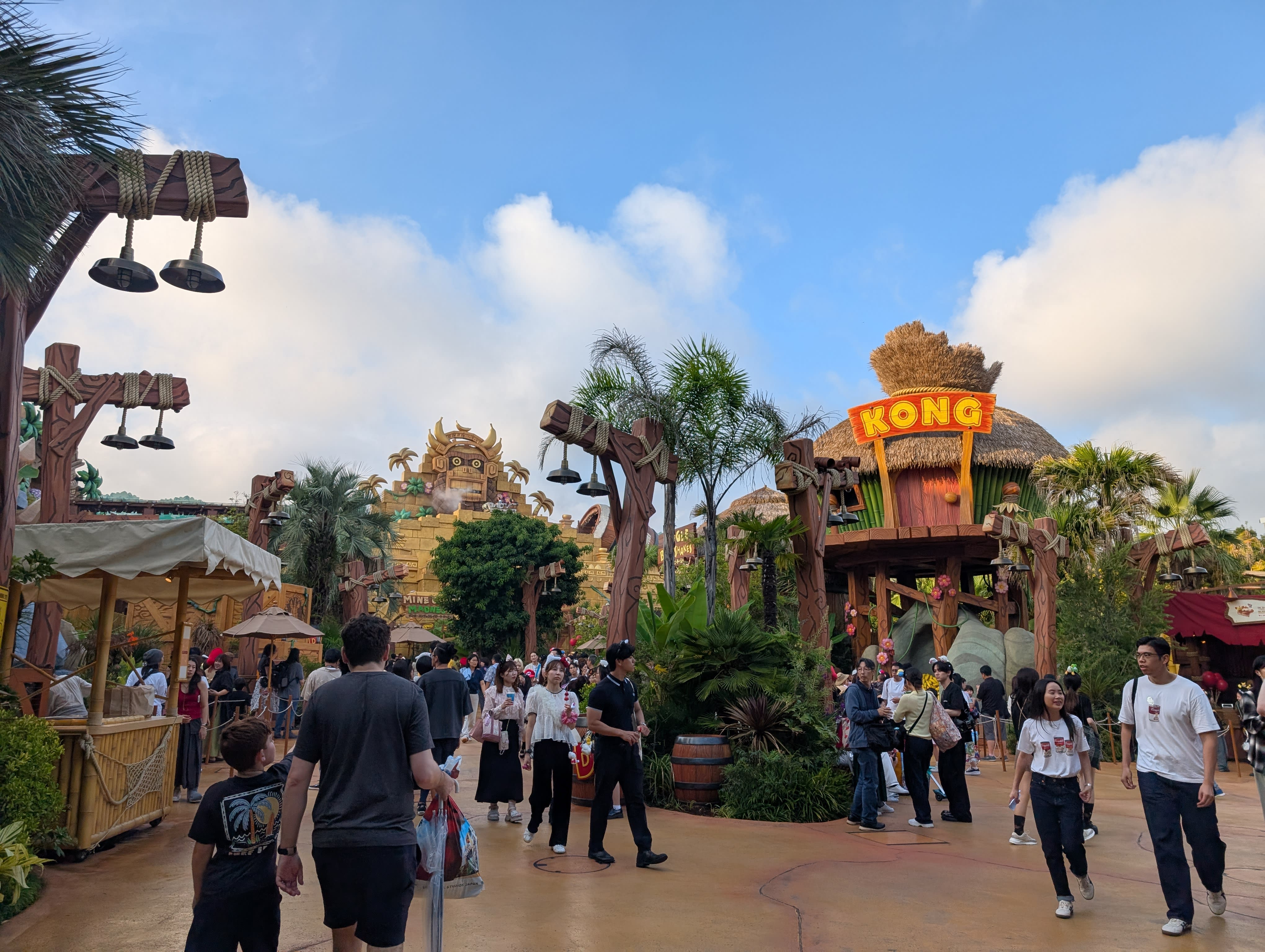 Donkey Kong Country in full — the Kong sign, the tiki huts, the artificial jungle, visitors wandering through what is essentially a living video game