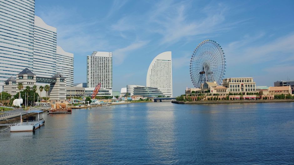 The two restored Red Brick Warehouses of Yokohama, their weathered brick facades lit warmly at dusk with the harbor promenade in front