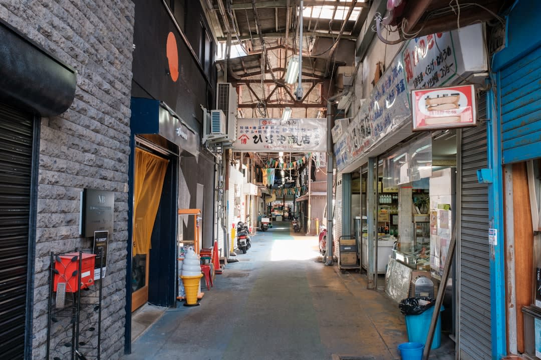 A narrow Yokohama Chinatown street at night, hung densely with glowing red lanterns and steam rising from a pork-bun stall