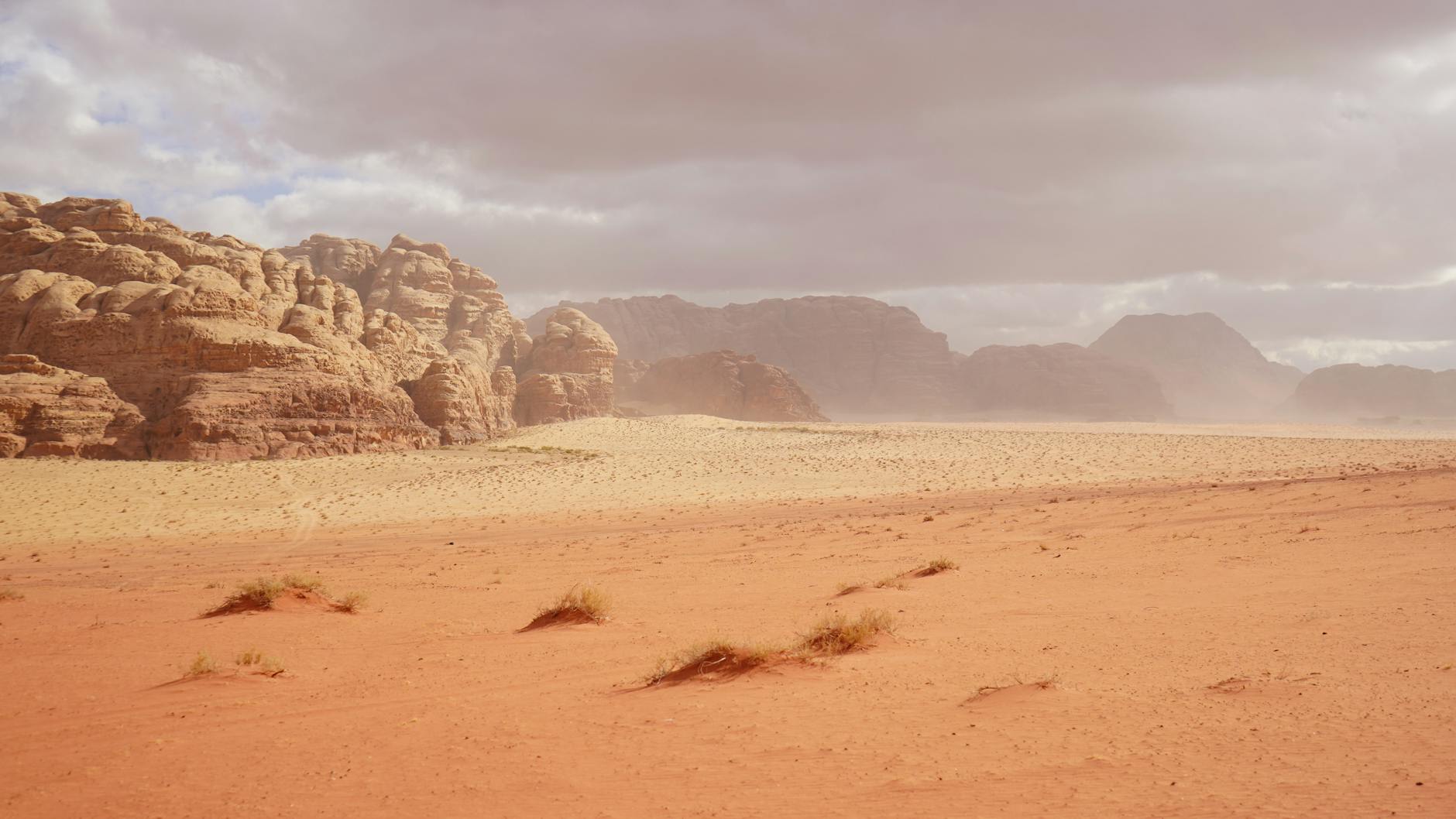Red sand desert landscape with towering sandstone formations in Wadi Rum