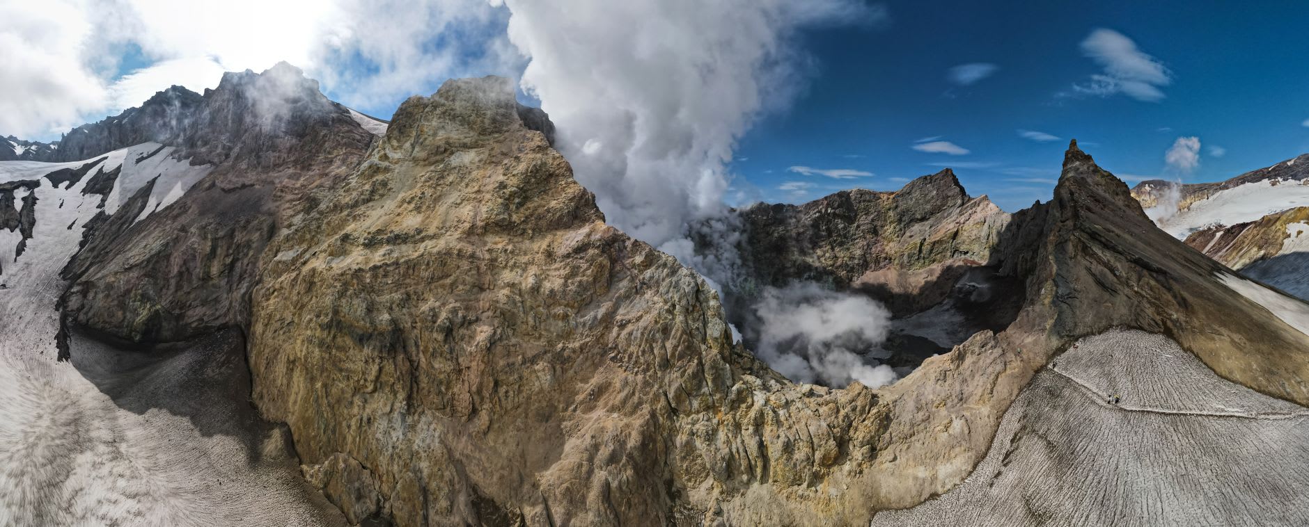 Le bord du glacier du Mutnovsky où il rencontre le champ de fumerolles actif, la surface de la glace teintée de jaune et s'effondrant dans des bassins acides fumants en dessous