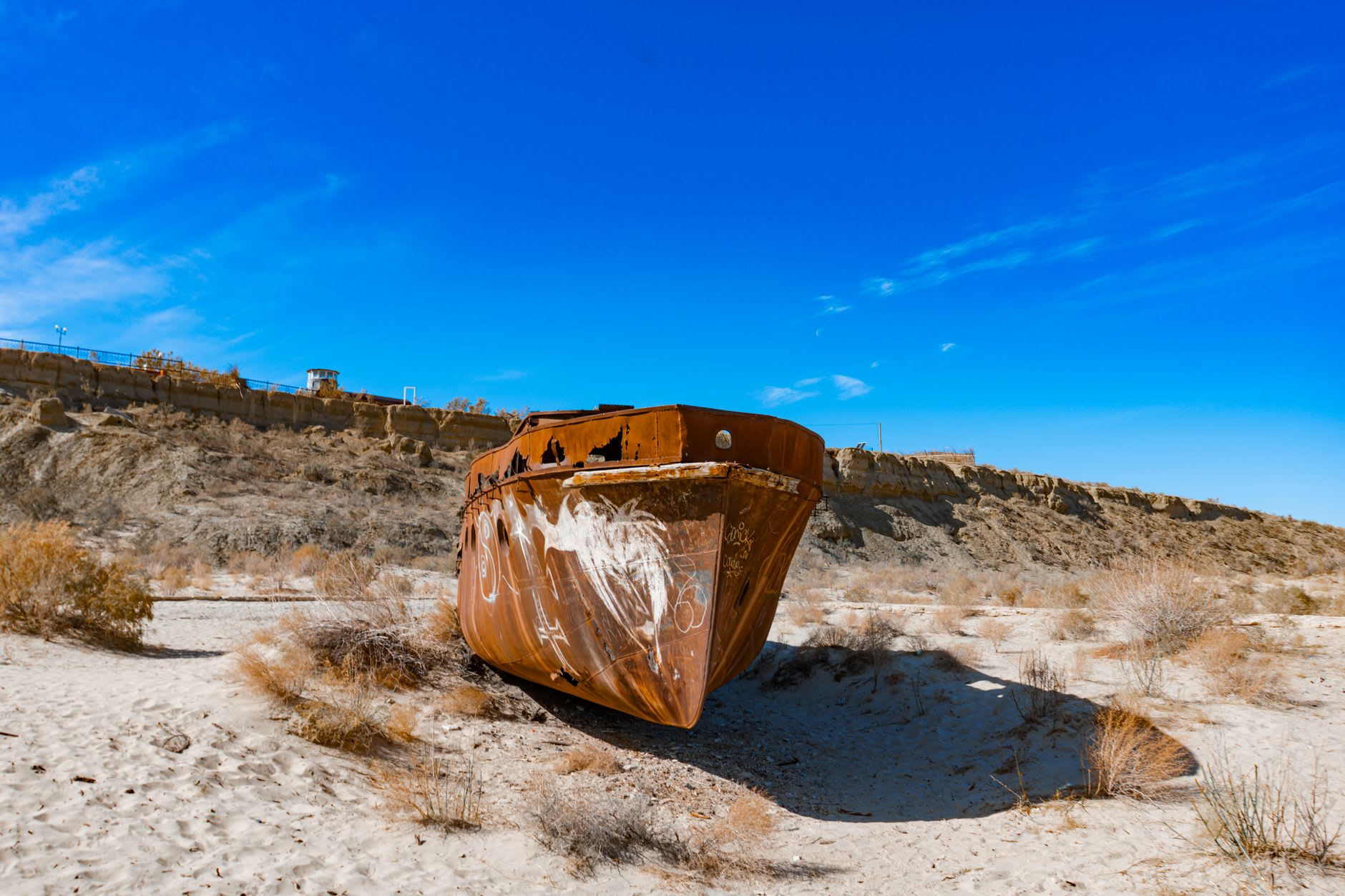 The old fishing harbor at Aralsk, its stone quays and rusting bollards now surrounded by cracked earth where the Aral Sea once reached