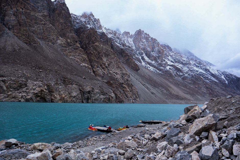 Turquoise water of Big Almaty Lake lapping against a rocky shoreline
