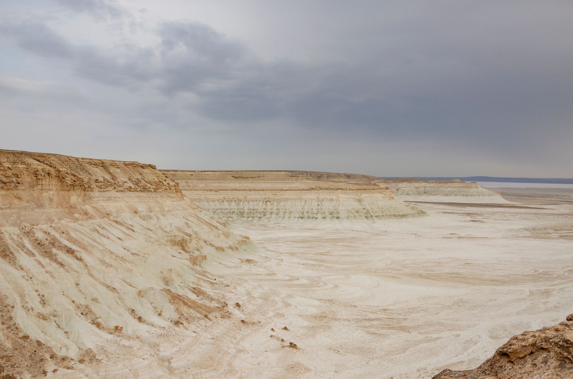 The chalk towers of Bozzhyra rising from the desert floor at Mangystau, their white limestone glowing against the deep blue sky
