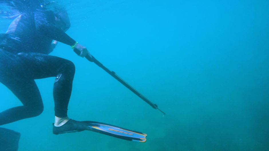 Adolescentes pescando con arpón en las aguas poco profundas de la laguna de Aranuka usando arpones tallados a mano