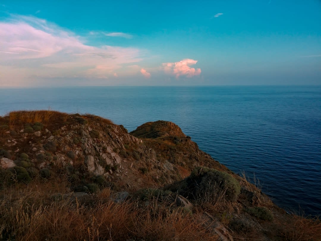 View from a limestone cliff at the southern tip of Arorae at dusk, open ocean stretching to the horizon with no other land visible