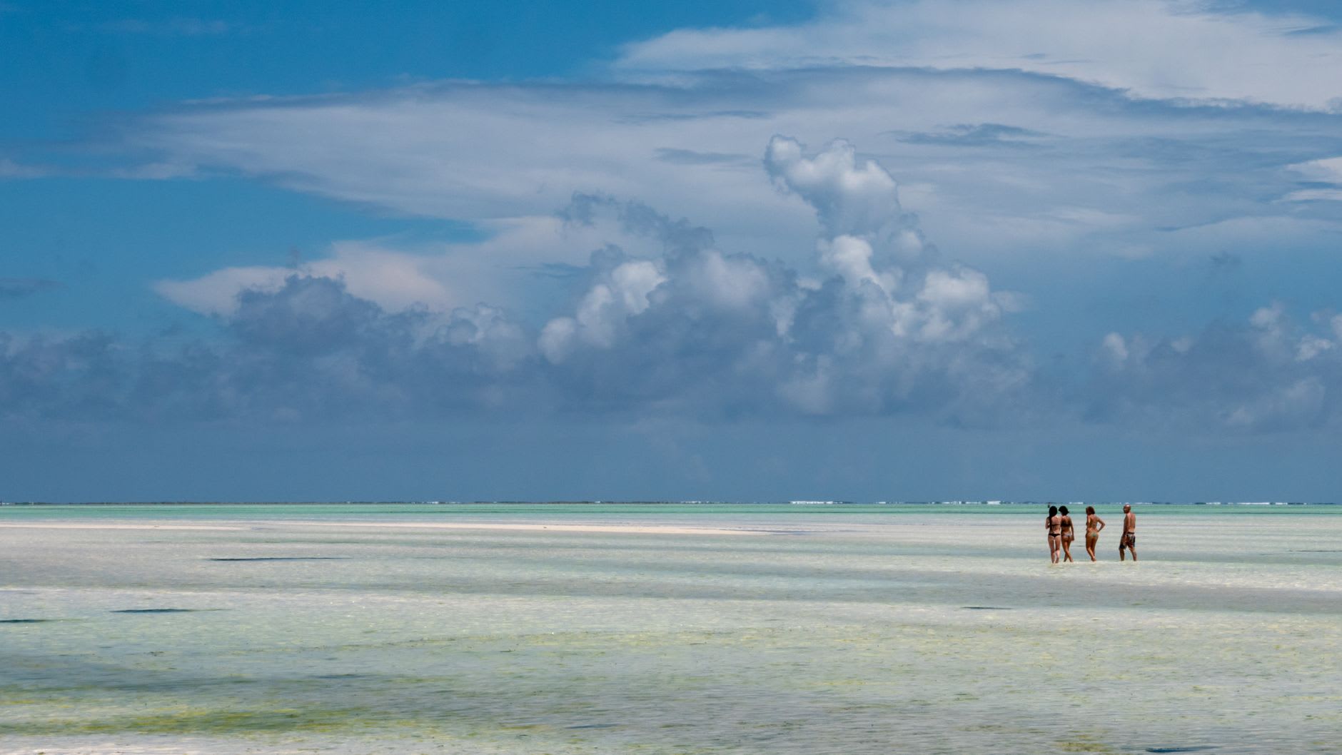 Rusted hull of a WWII landing craft half-submerged in the lagoon at low tide, Betio