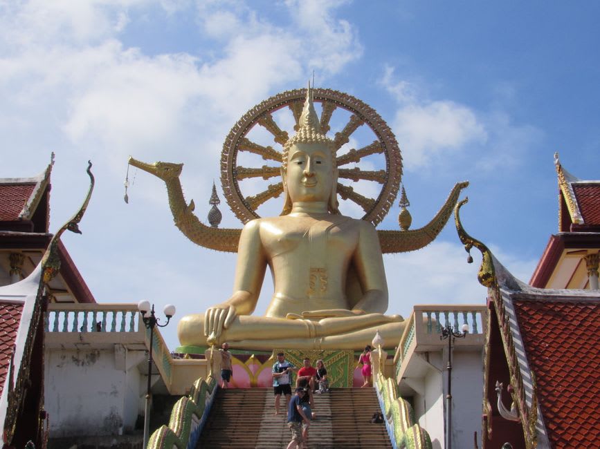 The gold-and-white Maitreya statue smiling above the temple grounds at Wat Plai Laem
