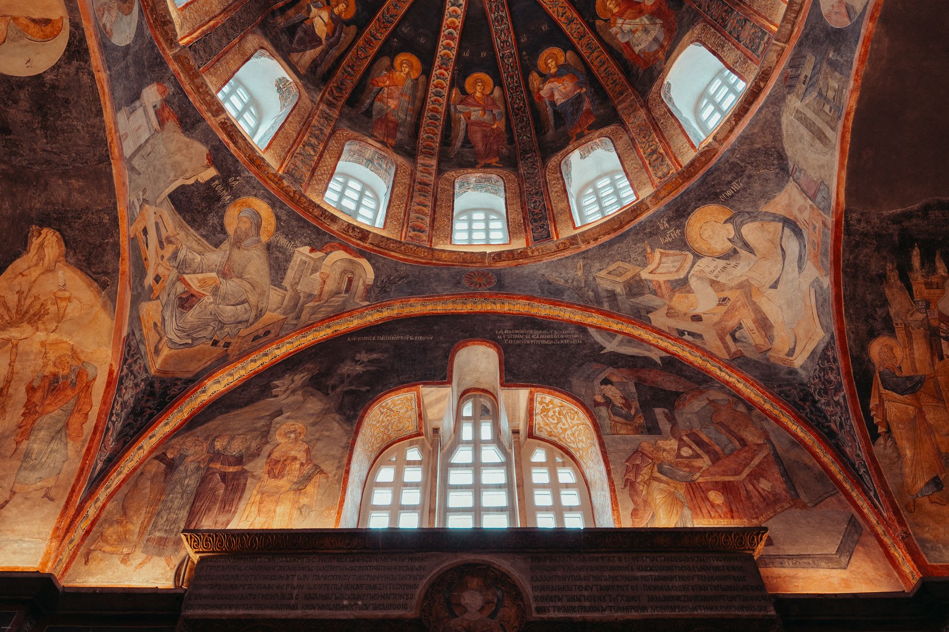 The five Byzantine domes of Gračanica monastery rising in tiers, stone walls patterned with alternating brick courses