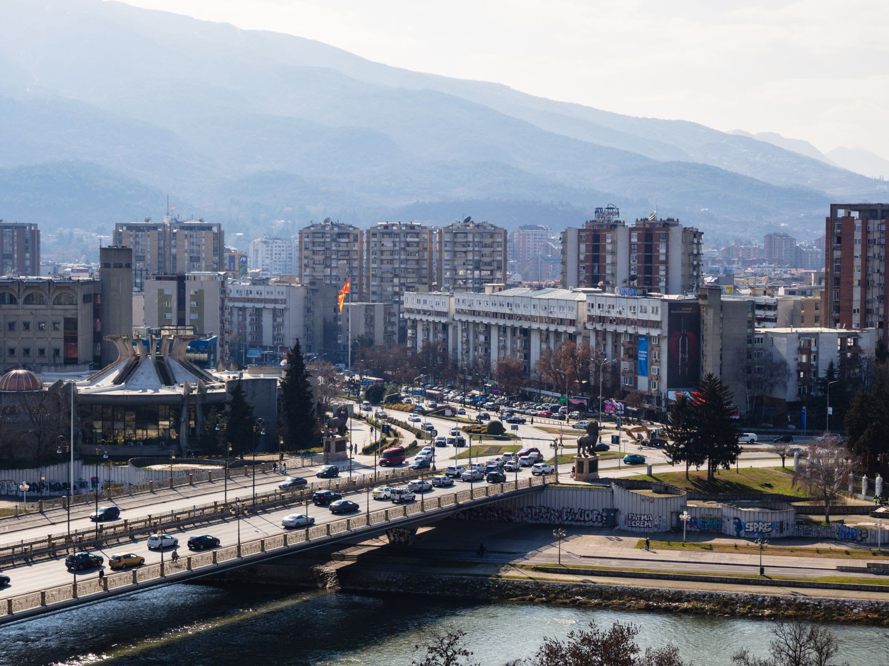 Des véhicules de maintien de la paix de la KFOR près de l'extrémité nord du pont principal de Mitrovica, drapeaux serbes visibles sur les bâtiments