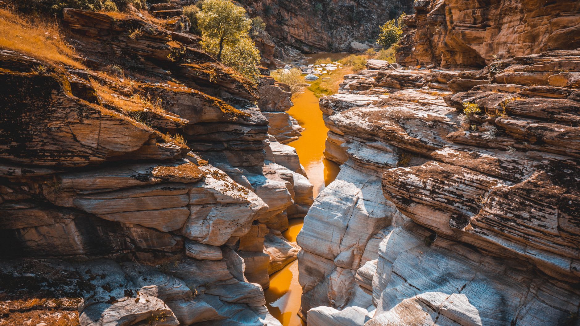 Hikers on a narrow trail above the Rugova gorge with sheer limestone walls rising on both sides