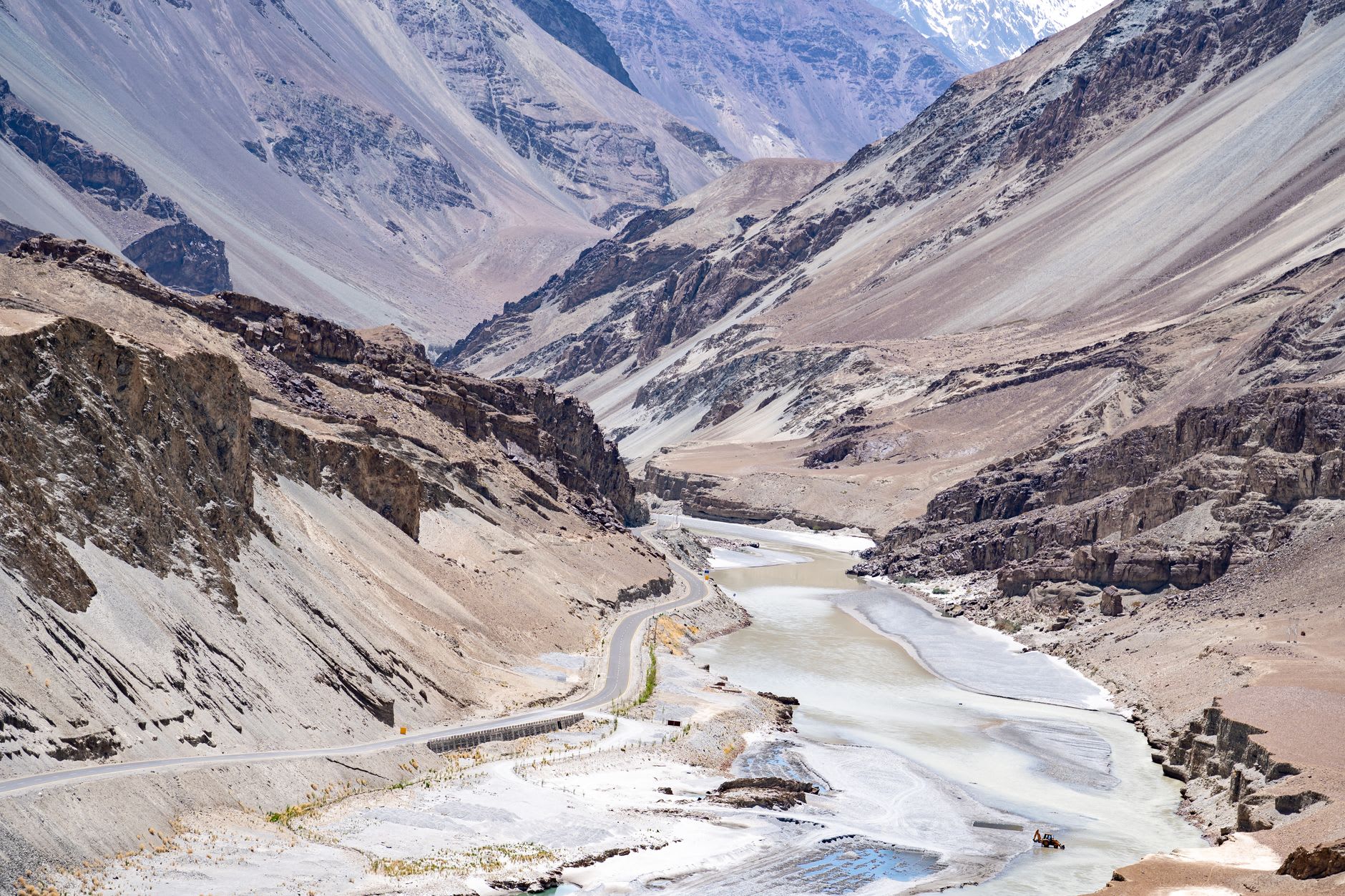 Apricot orchards in full fruit near Sumur village with stone walls and the bare Ladakhi ridges rising behind