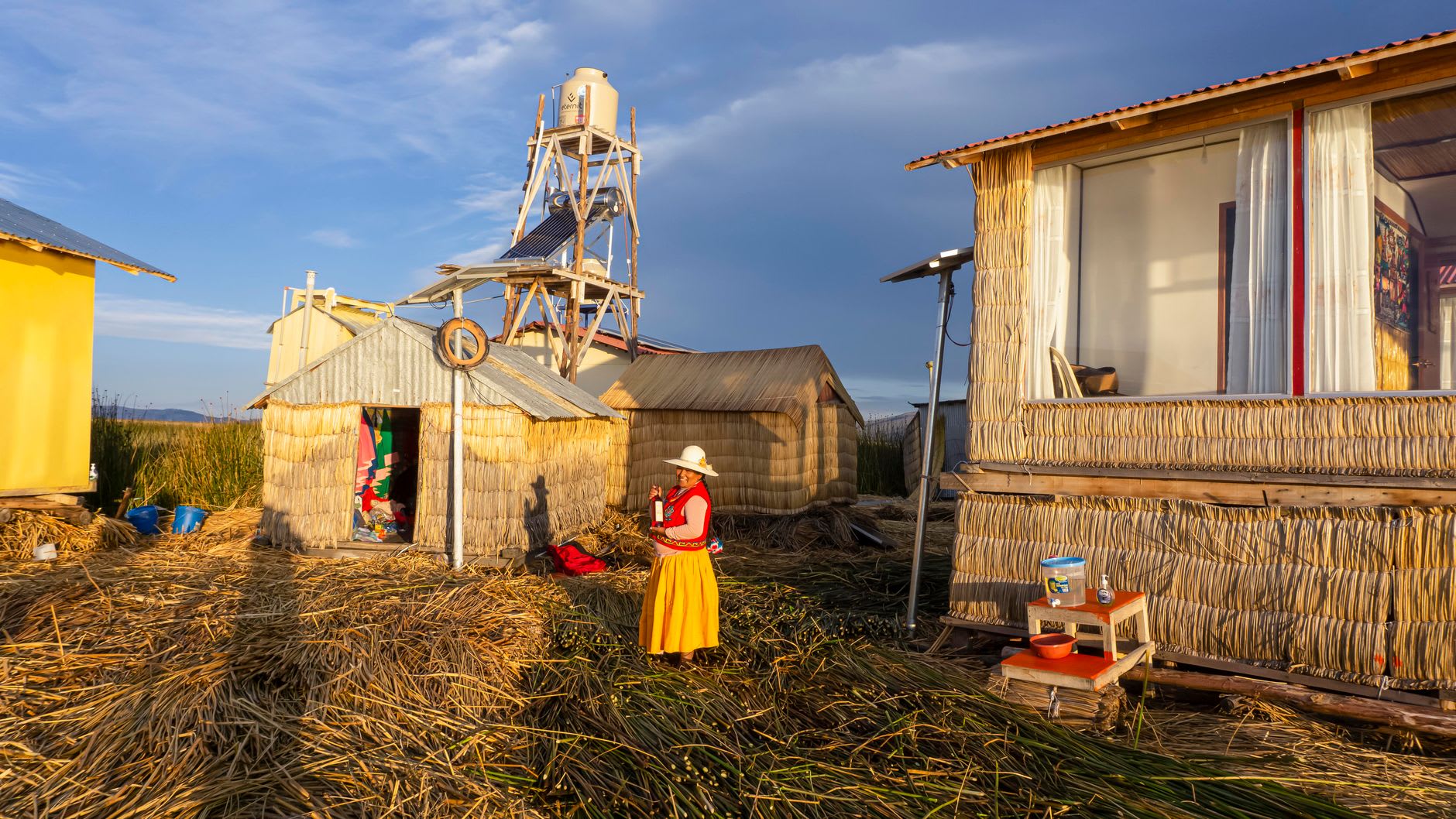 Rufina's courtyard on Amantaní with traditional adobe walls and quinoa drying on a woven mat