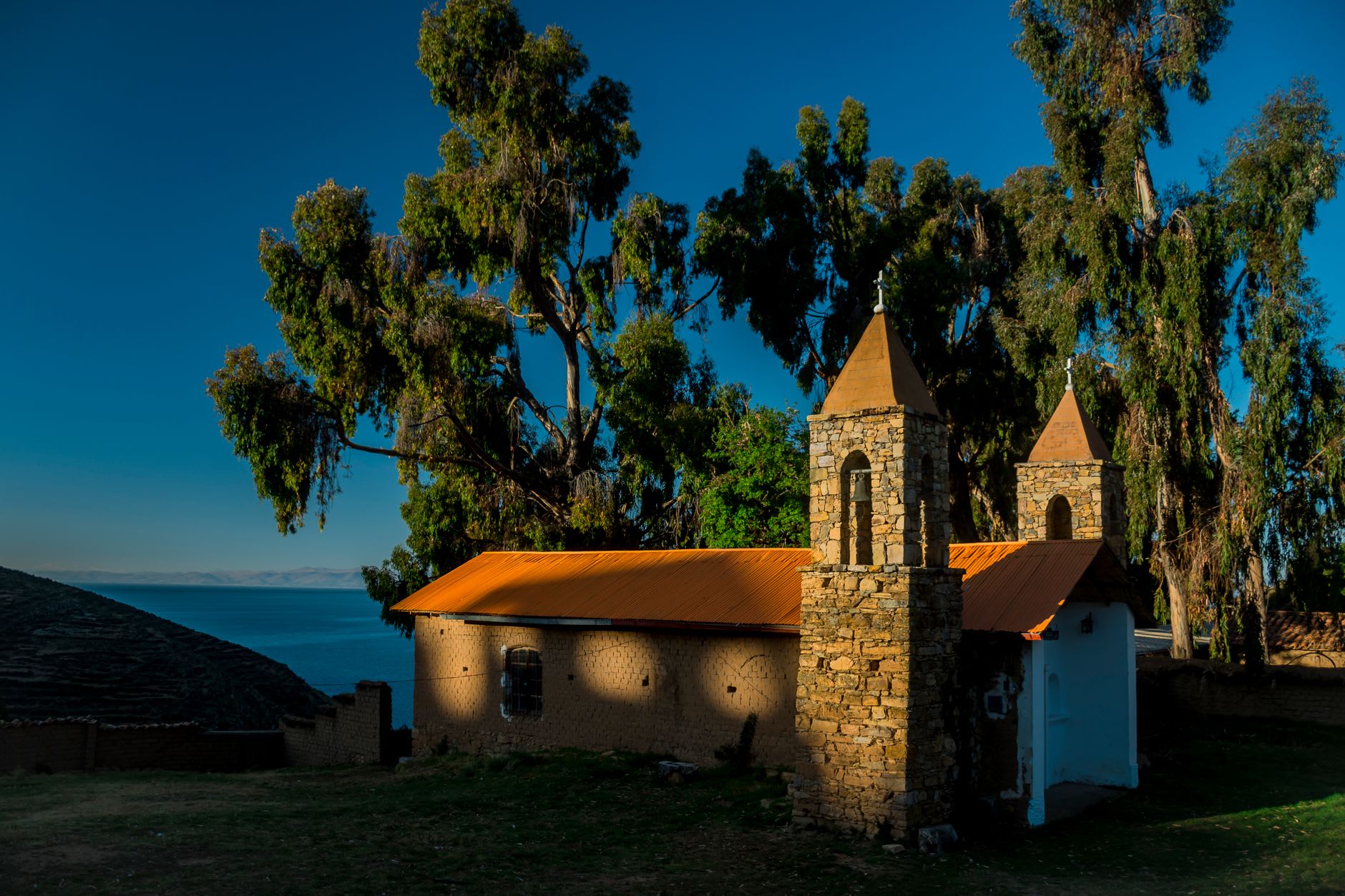 The restored courtyard wall of Iñak Uyu on Isla de la Luna, its tall trapezoidal niches open to the wind off the lake