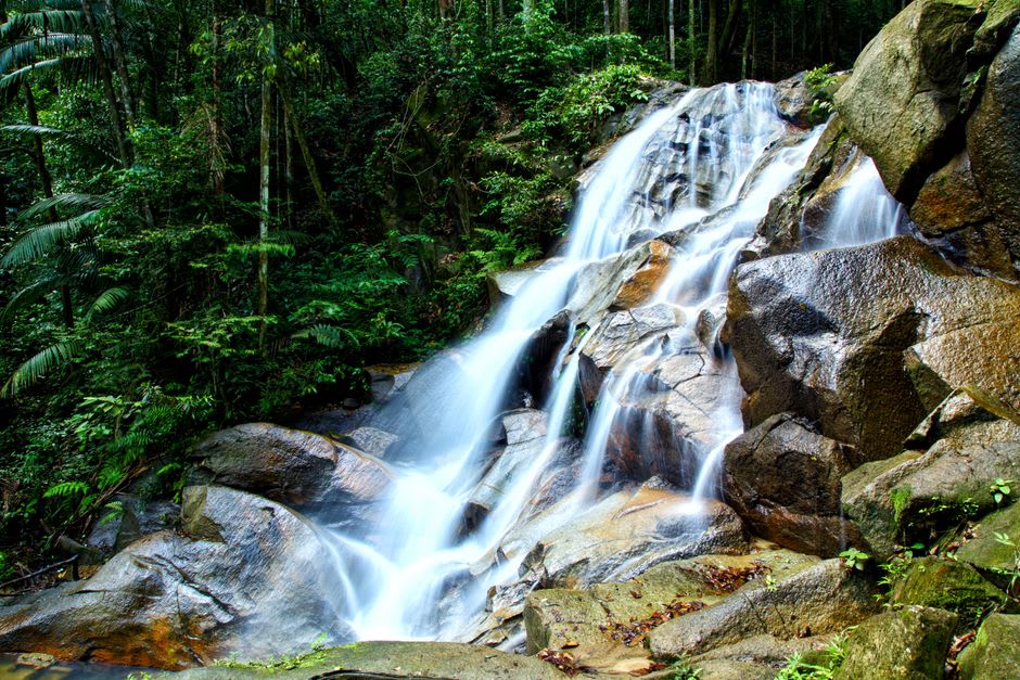 The tiered rock terraces of Durian Perangin Waterfall descending through the jungle