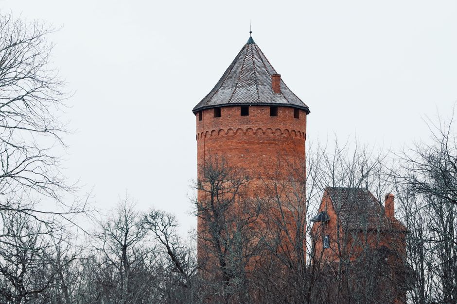 The red-brick main tower of Turaida Castle seen from the surrounding parkland