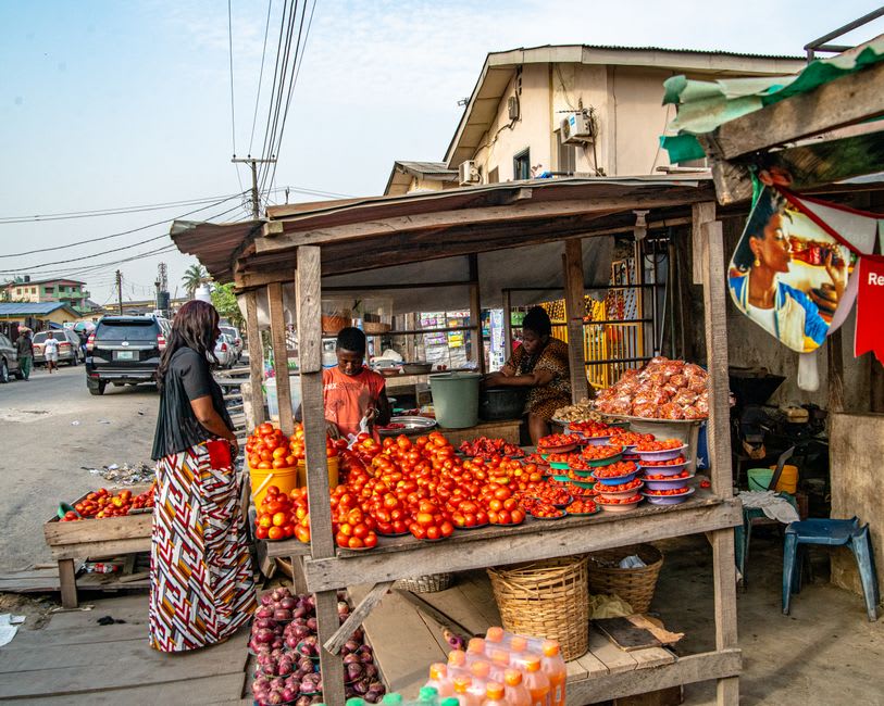 Sacks of produce and roasted corn vendors in Kakata's central market