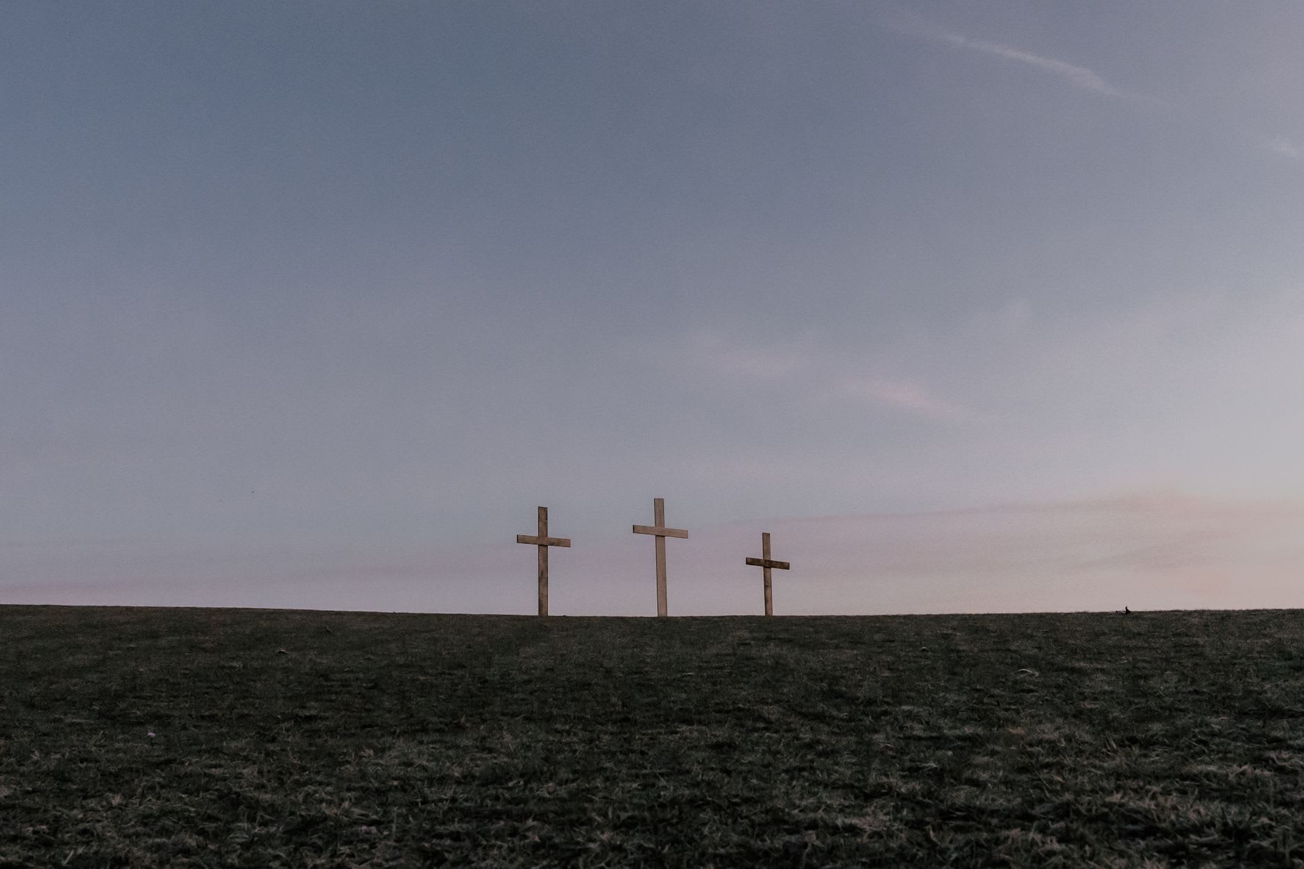 A close view of the cross layers at the Hill of Crosses showing wooden folk crosses, metal crucifixes and small medallions