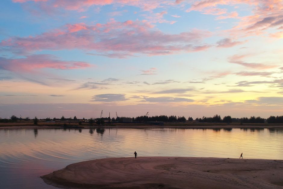 Sandbar campsite along the Capanaparo River at dusk with the gallery forest silhouette in the distance