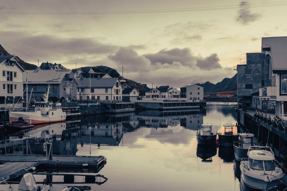 Fishing boats moored in Stamsund harbor at midnight under the midnight sun