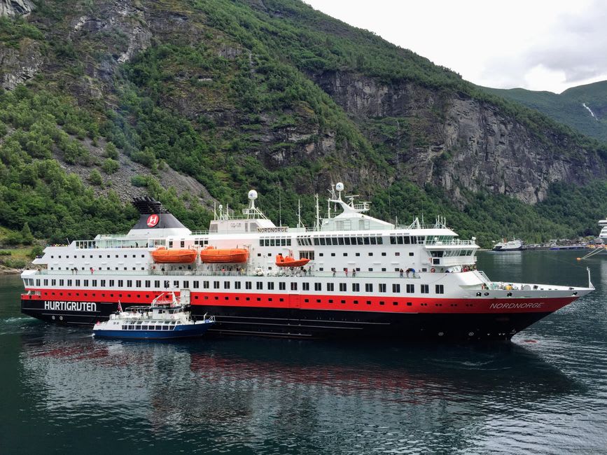 Hurtigruten coastal ferry maneuvering through the narrow entrance of Trollfjord with cliffs close on either side