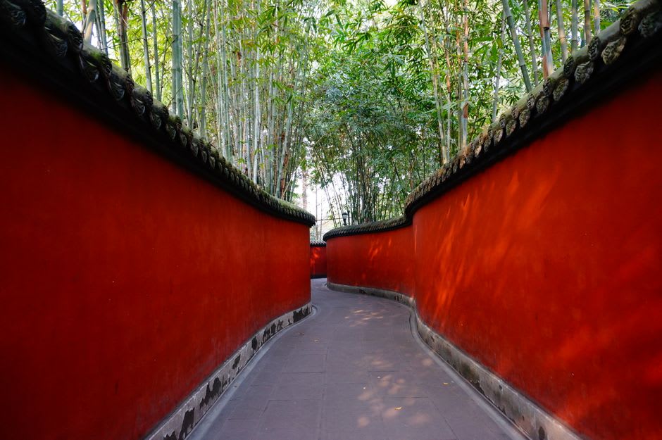 A stone pavilion framed by bamboo groves and artificial rockery in Lou Lim Ieoc Garden
