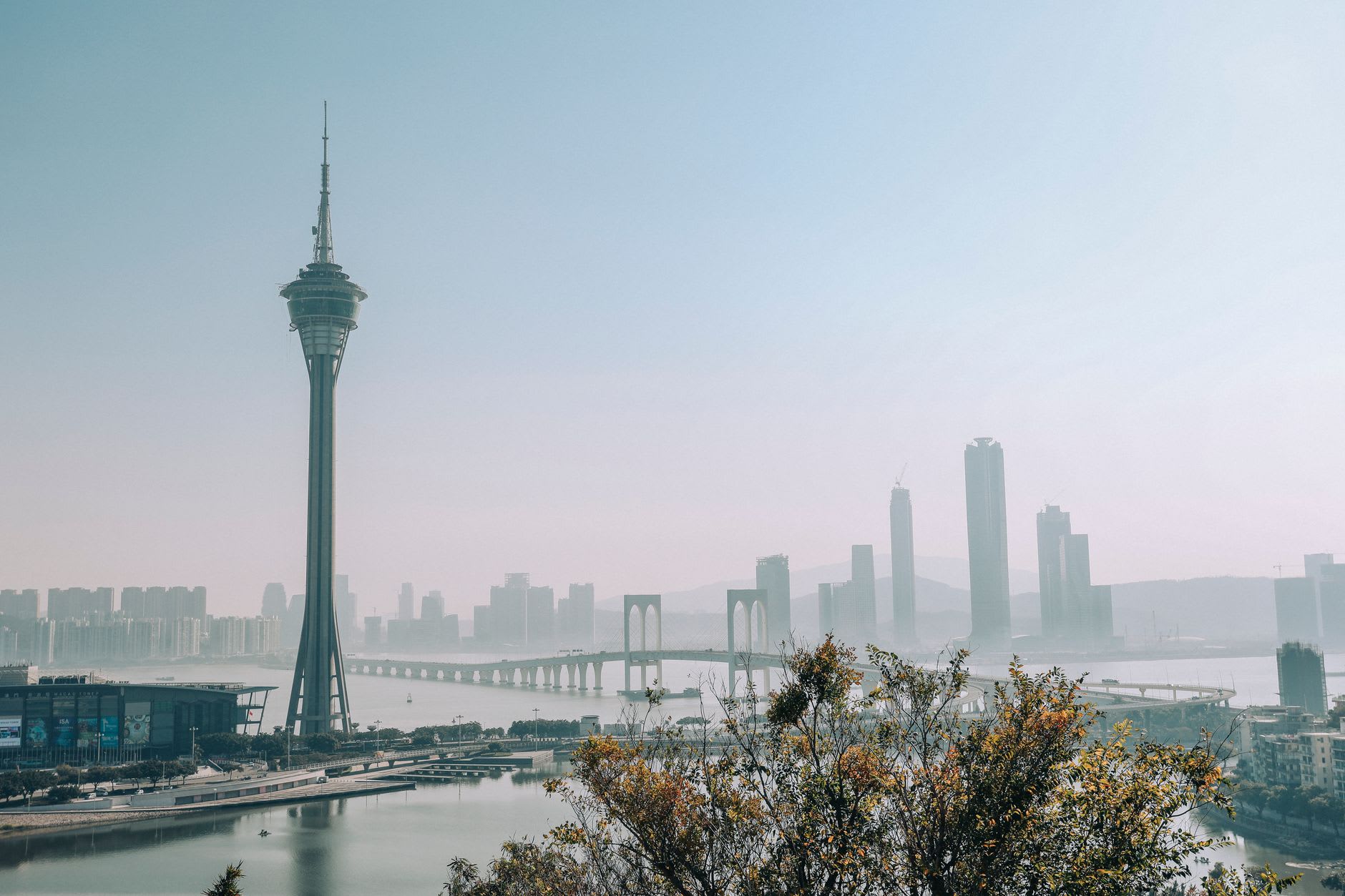 El giratorio 360 Café de la Torre de Macao al anochecer, comensales junto a la ventana con los casinos iluminados de Cotai extendiéndose más allá