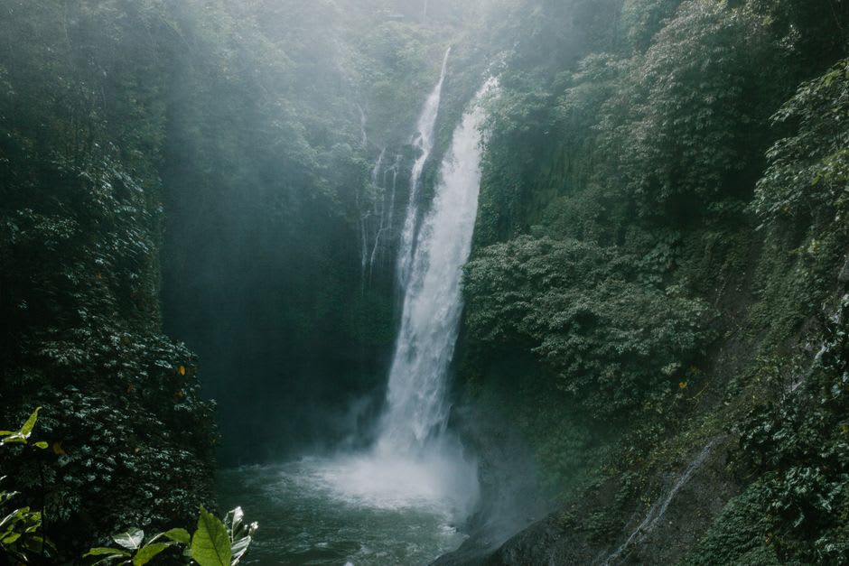 A clear cascading waterfall dropping through moss-covered boulders in a remote section of Mantadia National Park
