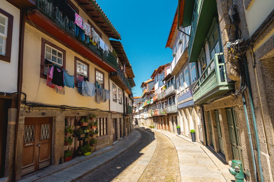 Narrow cobblestone street in Curral das Freiras lined with whitewashed houses and terraced gardens