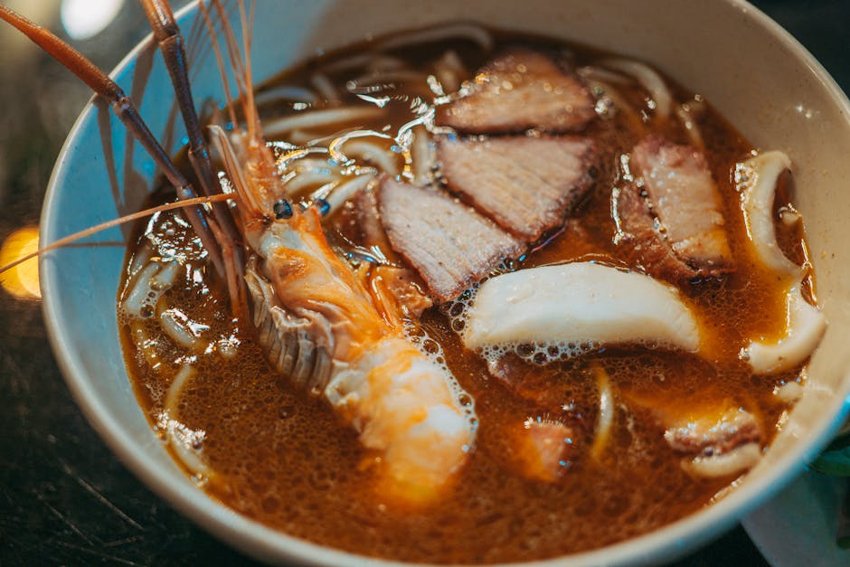 A steaming bowl of Ipoh hor fun noodles in clear broth