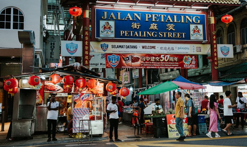 Bustling street food stalls and neon signs along Jalan Alor at night