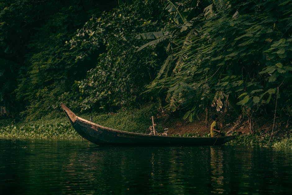 A longboat cutting through the still waters of the Tembeling River